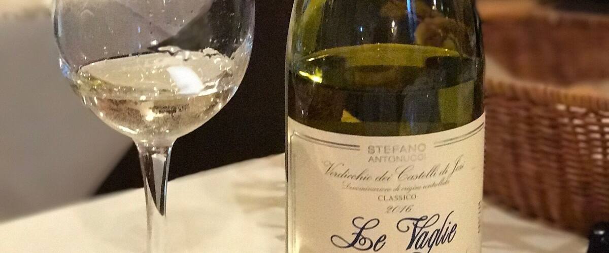 A bottle of wine and a wine glass on a table.
