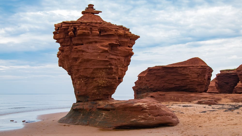 The Tea cup or pot a Red sandstone rock formation, sea stack, on a north shore beach in Darnley area of Prince Edward Island Canada, waves erode the lower rock leaving a free standing structure; Shutt