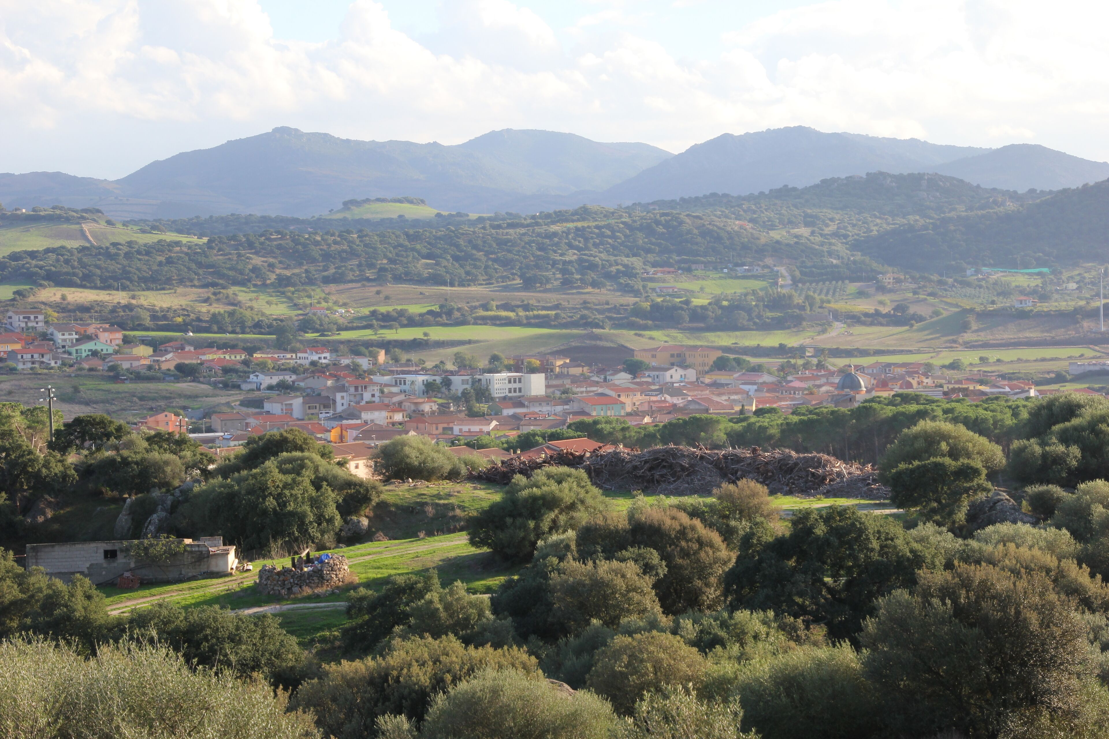 A town nestled in a valley with mountains in the background.