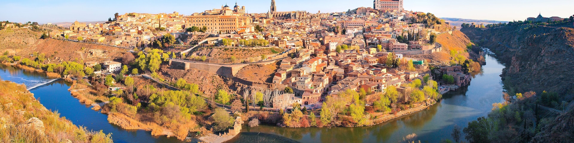 A panoramic view of a historic city with a river, including prominent buildings and a castle.