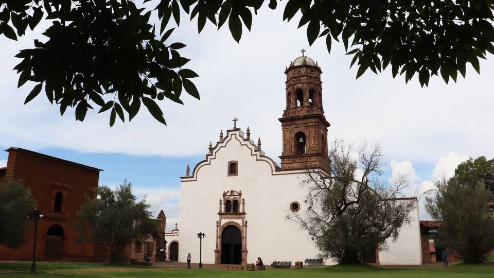 Convento de Santa Ana en Tzintzuntzan México visto detrás de un árbol