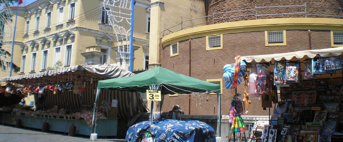 A street market with a Ferris wheel in the background.
