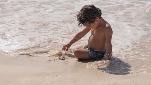 Young boy playing in sand on beach in caribbean