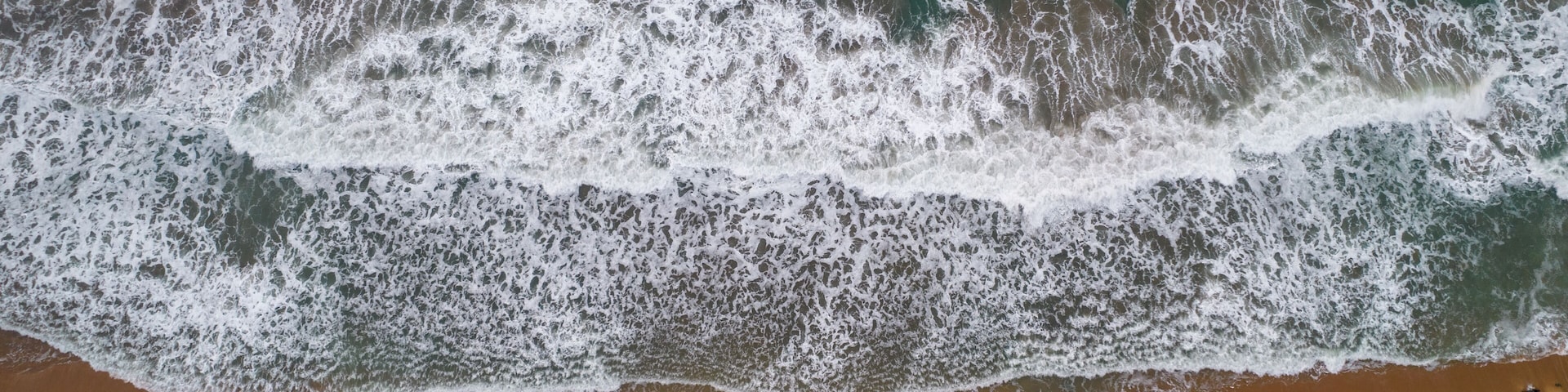 A rocky shoreline with waves crashing onto the beach.