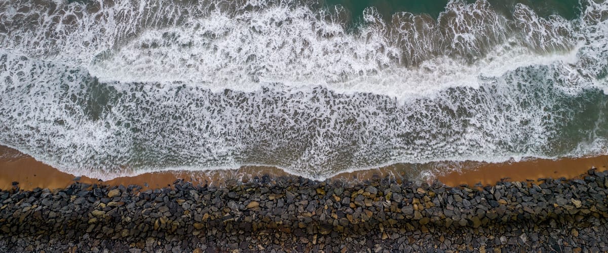 A rocky shoreline with waves crashing onto the beach.