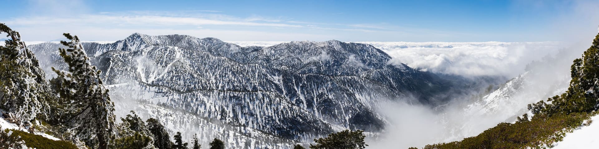 Sunny winter day with fallen snow and a sea of white clouds on the trail to Mt San Antonio (Mt Baldy), Los Angeles county, southern California