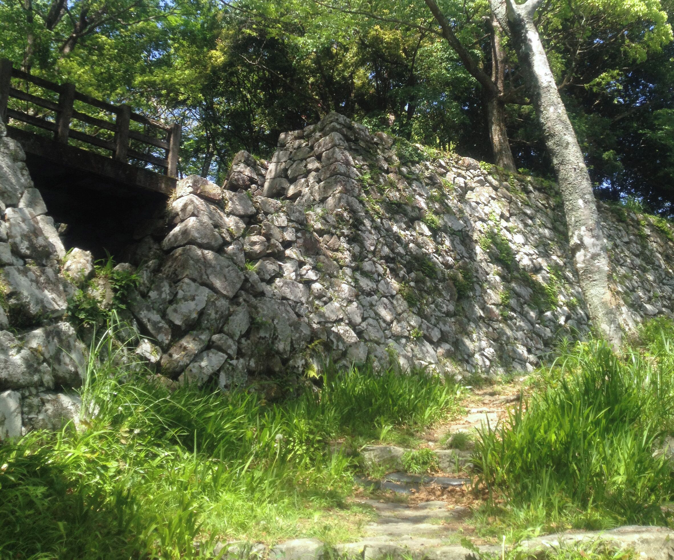 豊後国大分県佐伯市にあった佐伯城の登城山道より本丸南西石垣を見た。左の橋は二の丸と本丸の堀切に架かっていた廊下橋跡。