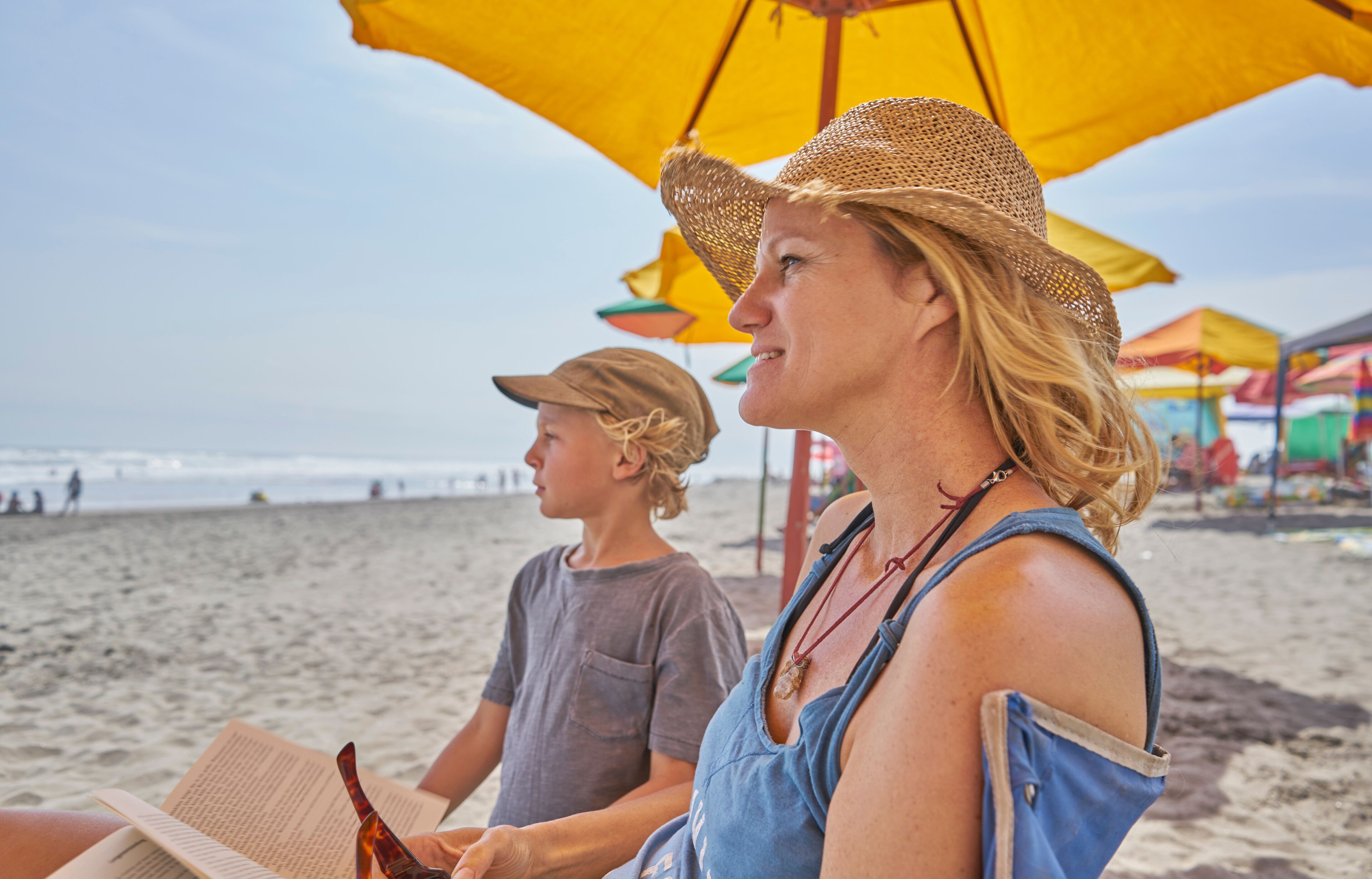 Mature woman and son relaxing on beach, Camana, Arequipa, Peru