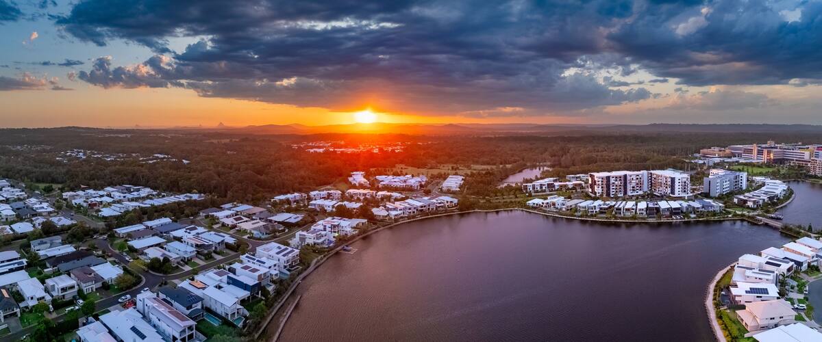 Aerial panorama of the Sun breaking through over waterfront property along inland canals