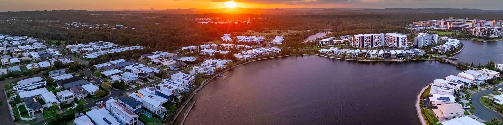Aerial panorama of the Sun breaking through over waterfront property along inland canals