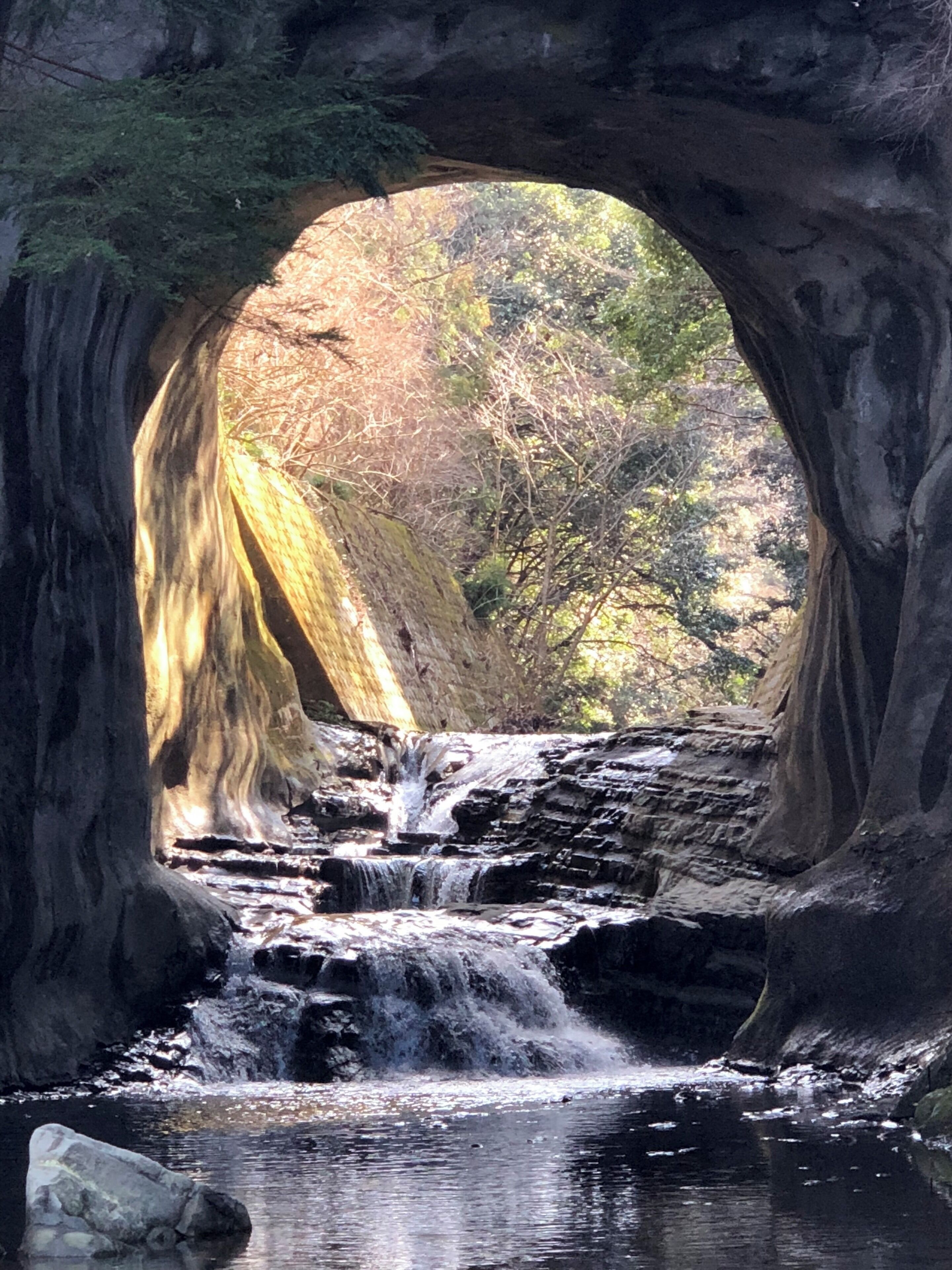 A waterfall cascading through a natural rock arch.