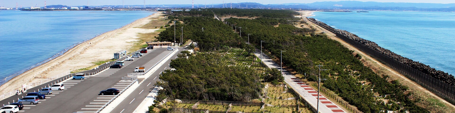 A coastal road with a roundabout, beach, and ocean.