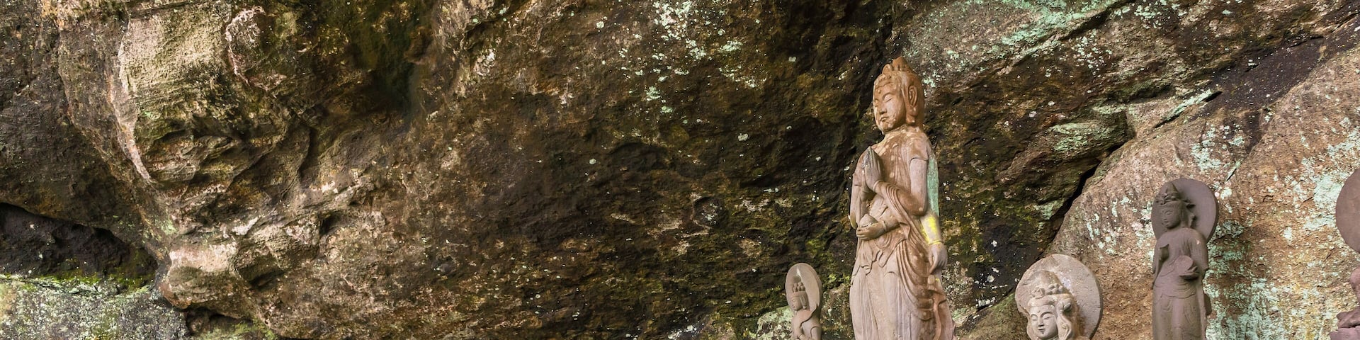 Buddhist statues of deities and monks surrounding the sculpture of Saigoku Kannon bodhisattva created in 18th century by Jingoro Eirei Ono in the Mount Nokogiri.
