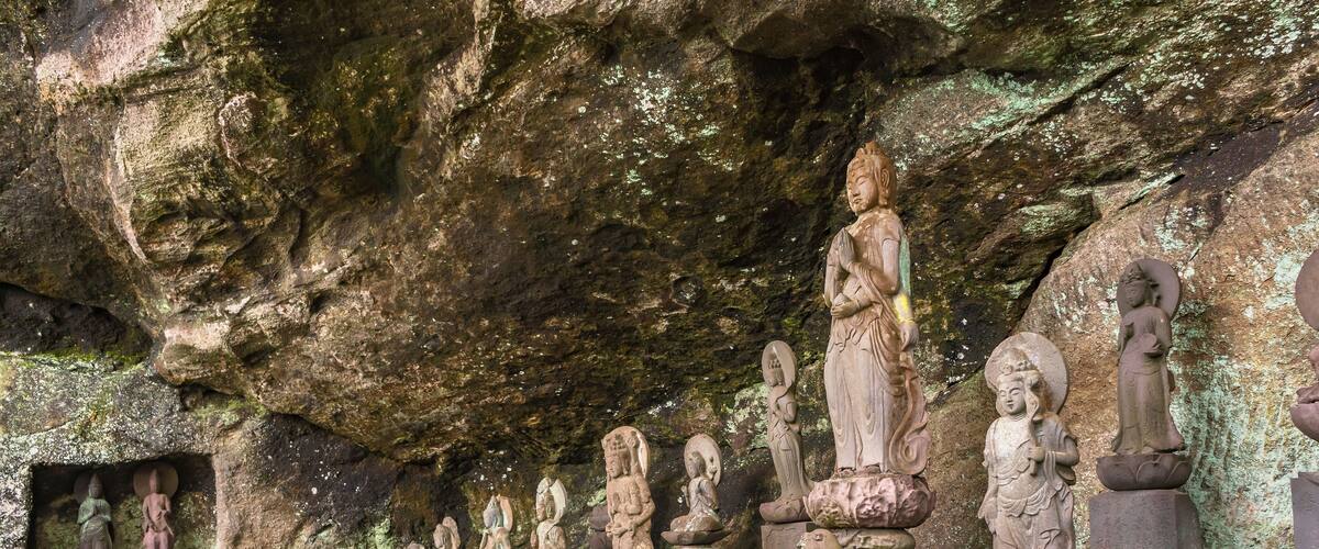A series of stone statues in a cave.