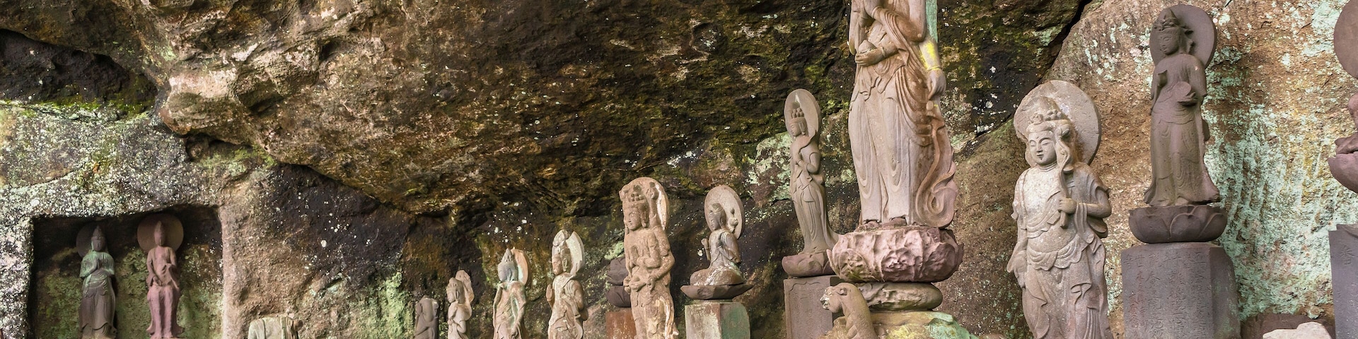 A series of stone statues in a cave.