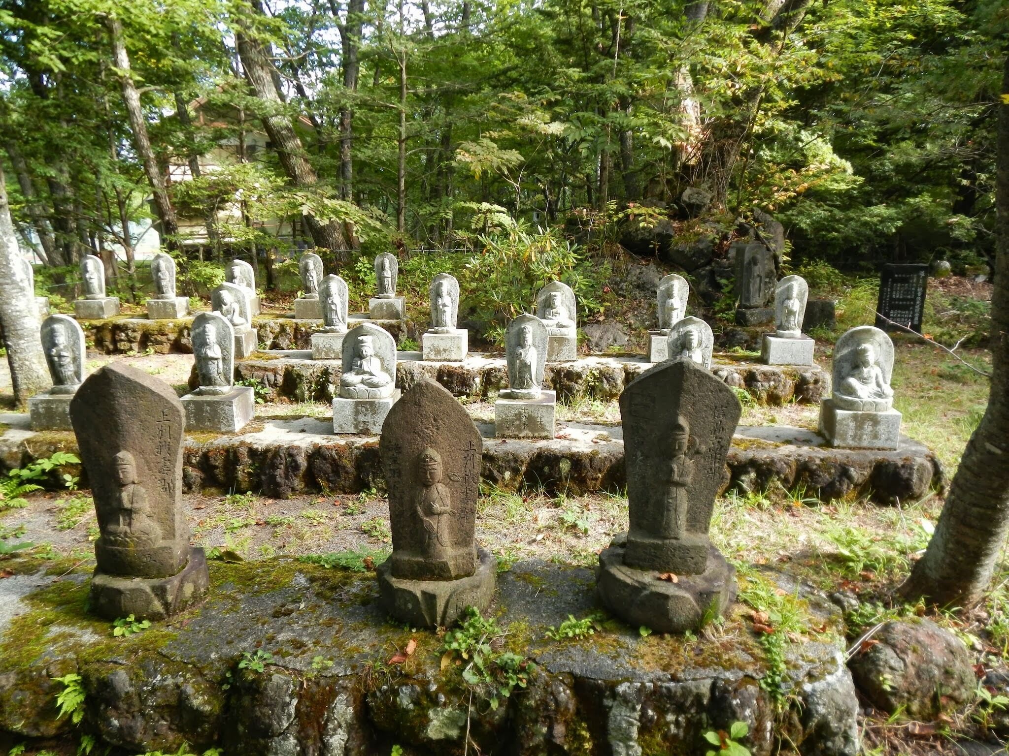 A cemetery with stone statues and tombstones.