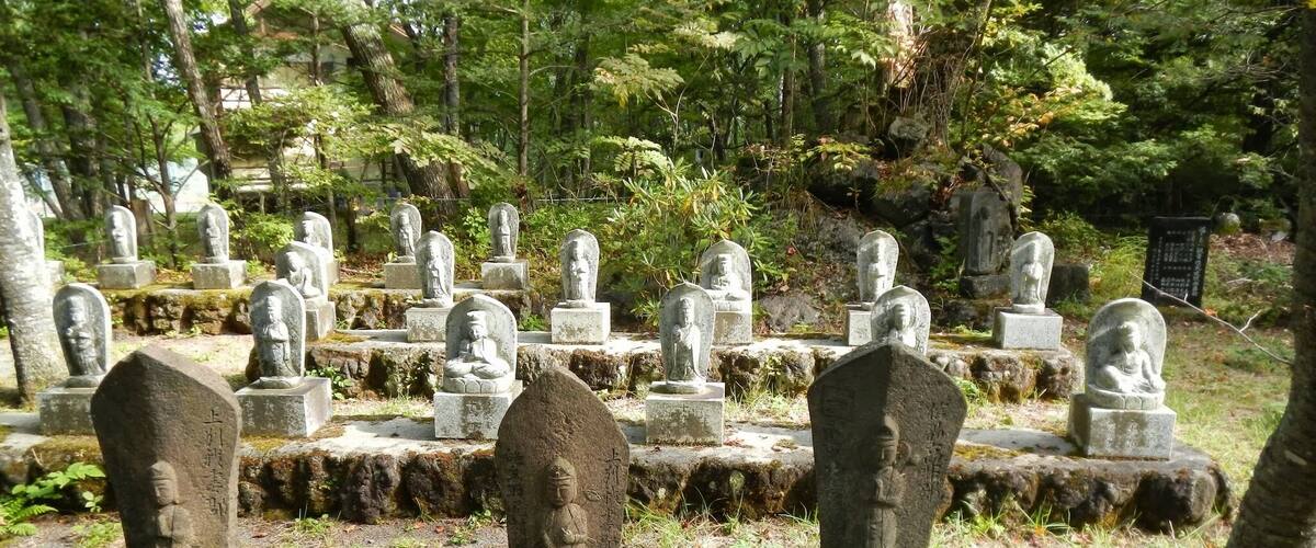 A cemetery with stone statues and tombstones.
