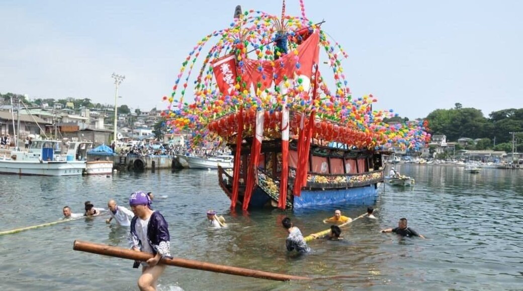 Kibune matsuri. Festival boats transport the portable shrine from one side of the harbor to the other. Boats are launched from the ramp using poles push/roll them into the water.