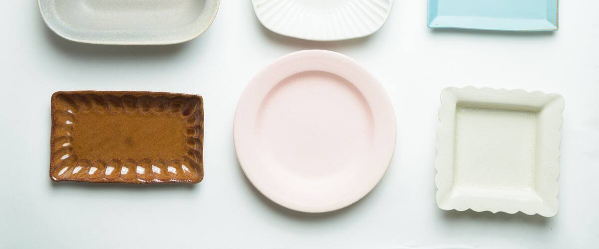 Six ceramic plates of different shapes and colors.