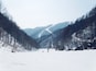 Un paysage de montagne enneigé avec une piste de ski.