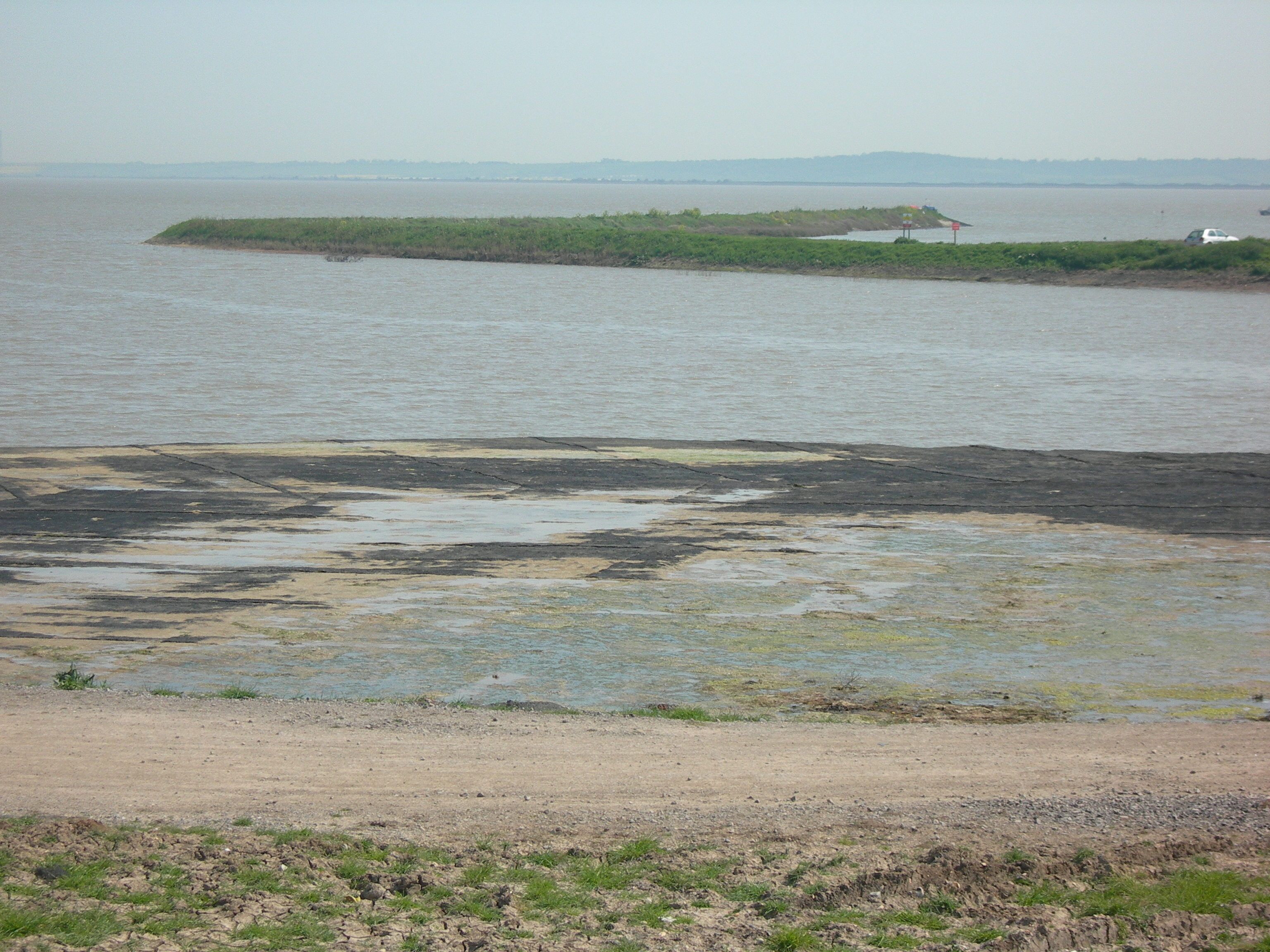 A river with a small island and a distant shoreline.