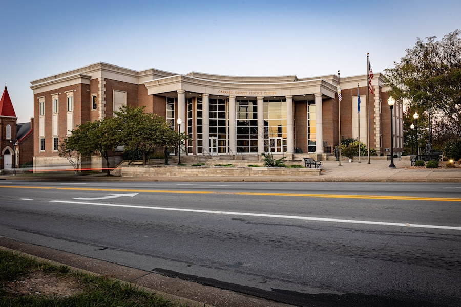A courthouse with a red roof, columns, and flags.