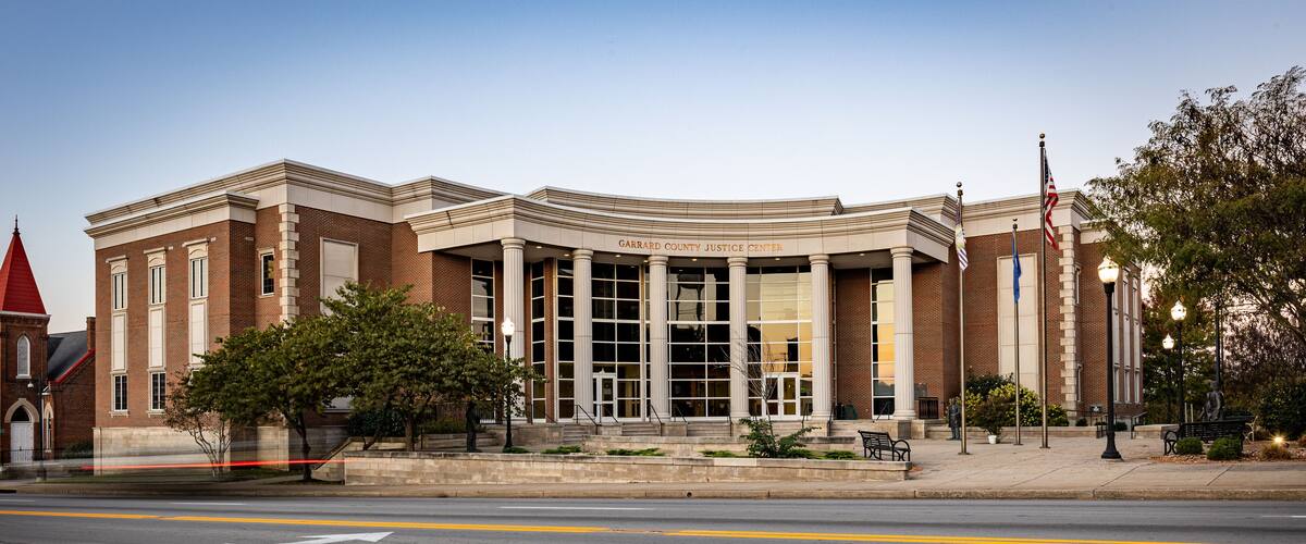 A courthouse with a red roof, columns, and flags.