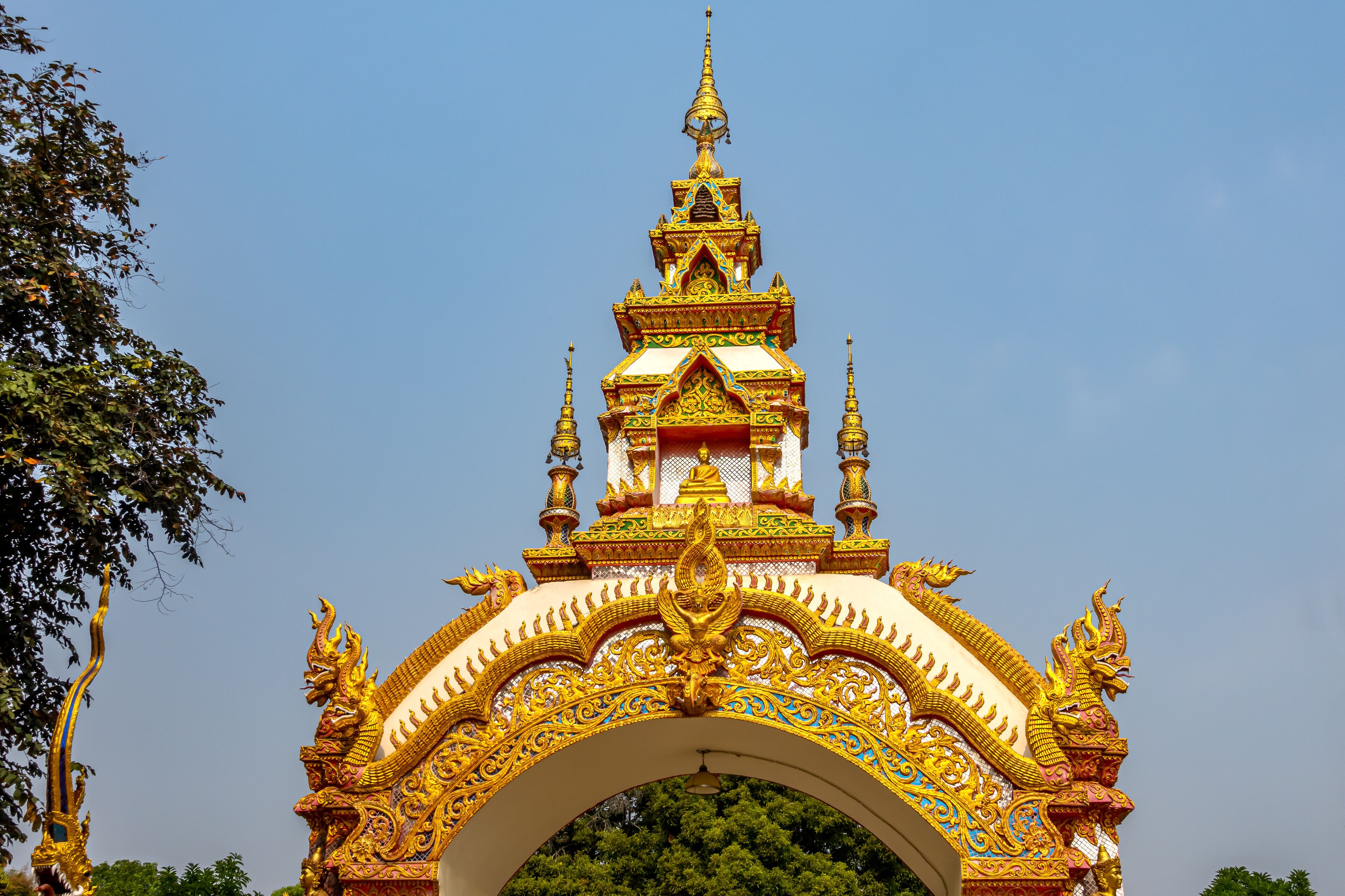 Decoration on the gate of Wat Khu Kum with the statues of Buddha, Naga, and Garuda in Muang District, Lampang Province, Thailand.