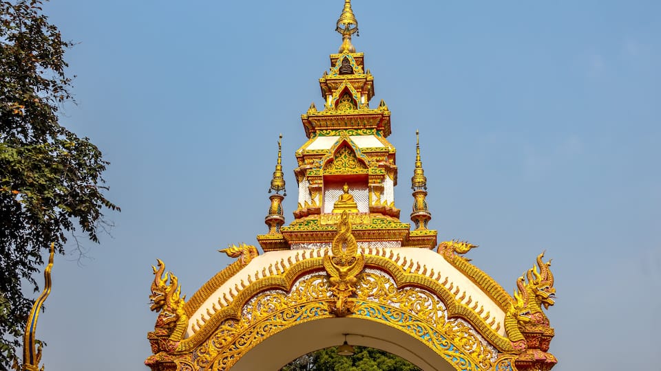 A golden temple with intricate designs and a pointed spire.