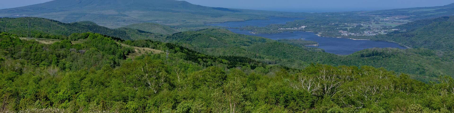 A mountain with a clear sky and scattered clouds.