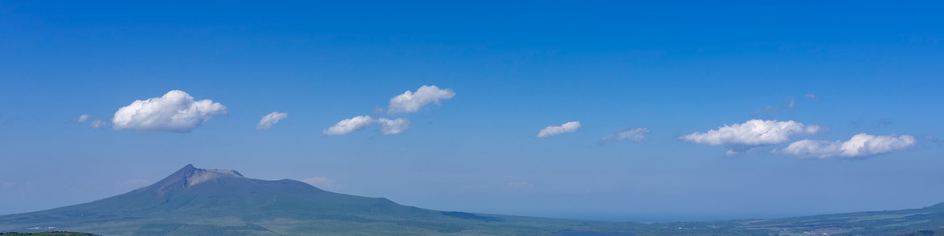 Montanha com céu limpo e algumas nuvens.