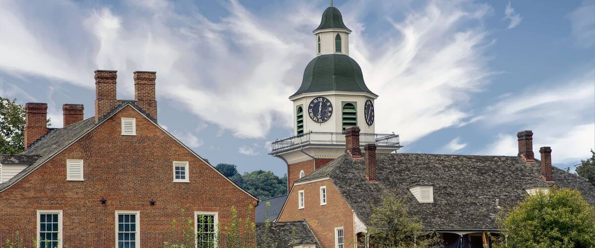 A historic building with a clock tower and brick chimneys.