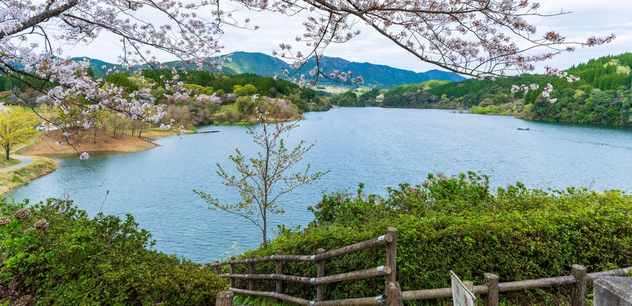 A serene lake surrounded by lush greenery and mountains.