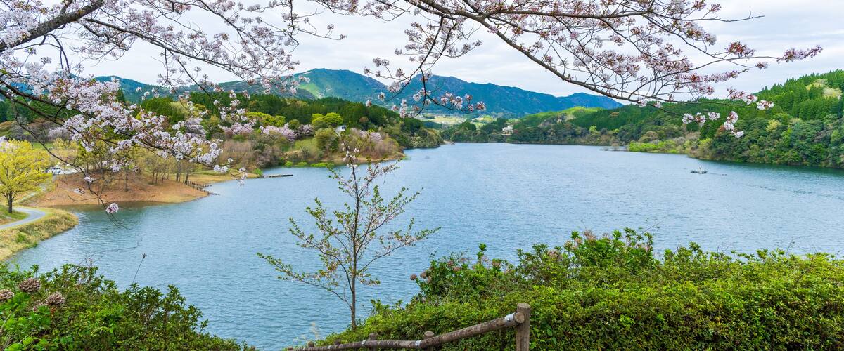 A serene lake surrounded by lush greenery and mountains.
