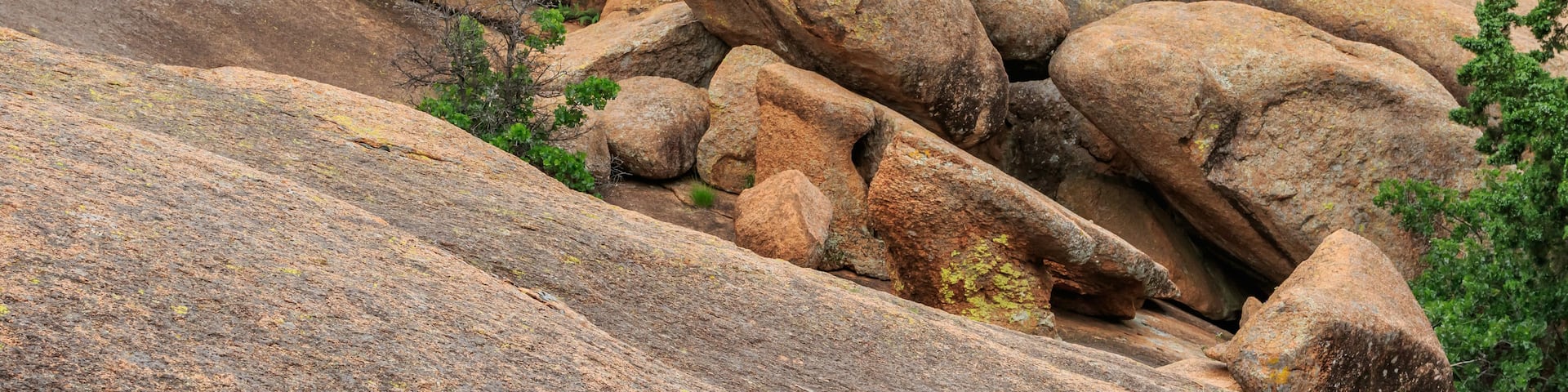 A rugged landscape with large boulders and sparse vegetation.