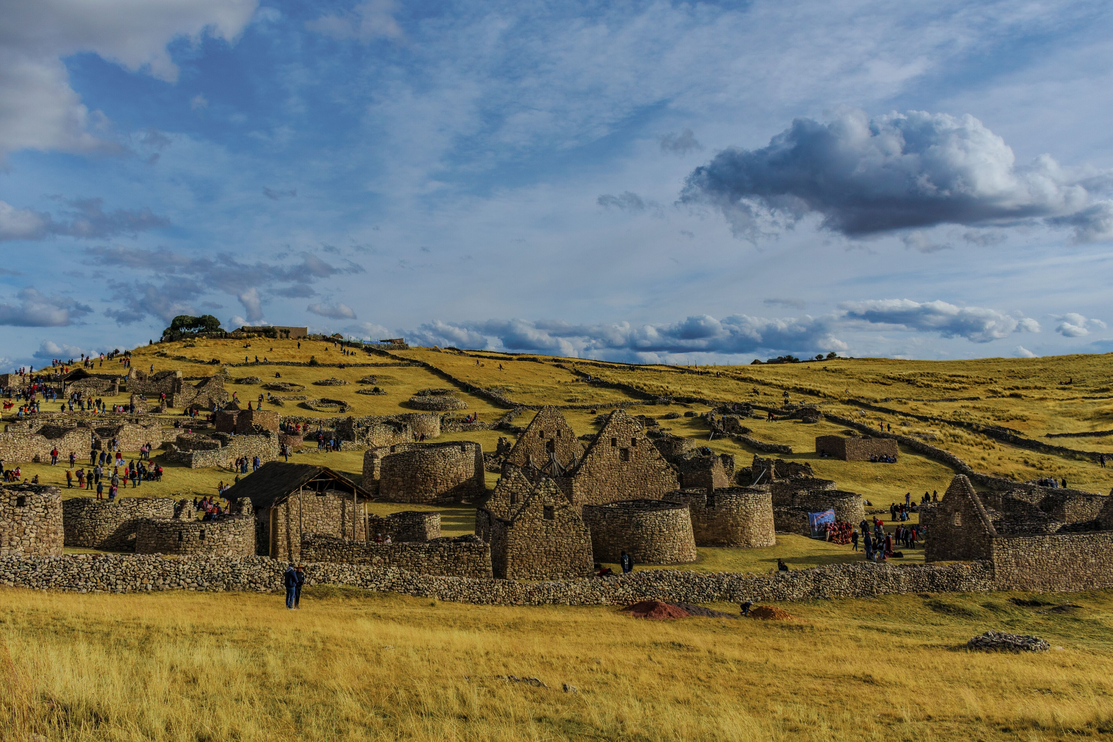 A historical site with stone ruins and a hilltop structure.