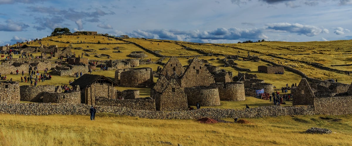 A historical site with stone ruins and a hilltop structure.