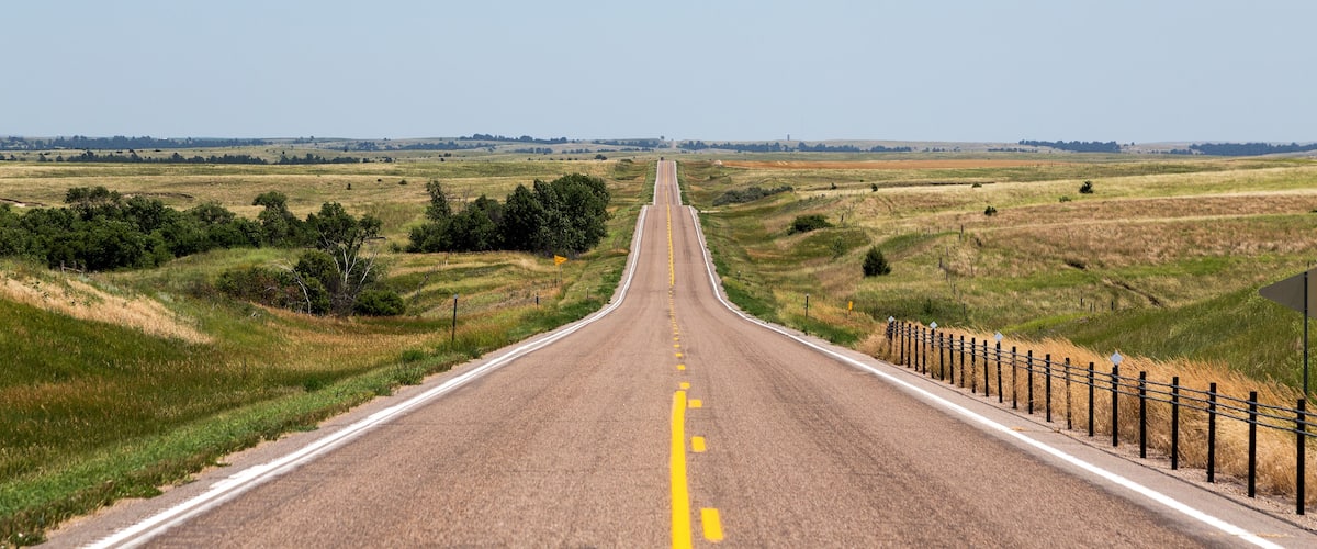 A road cutting through northern Nebraska on a summer day.
