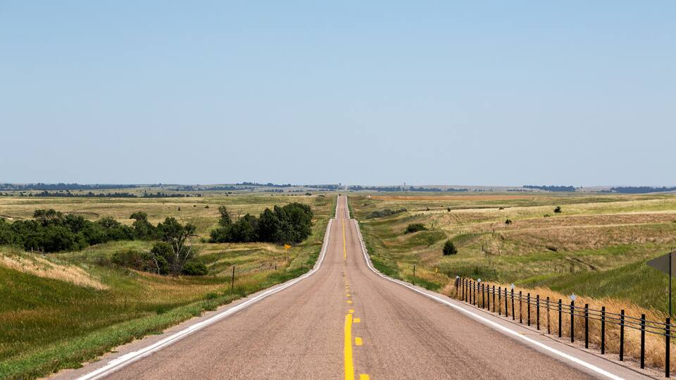 A road cutting through northern Nebraska on a summer day.