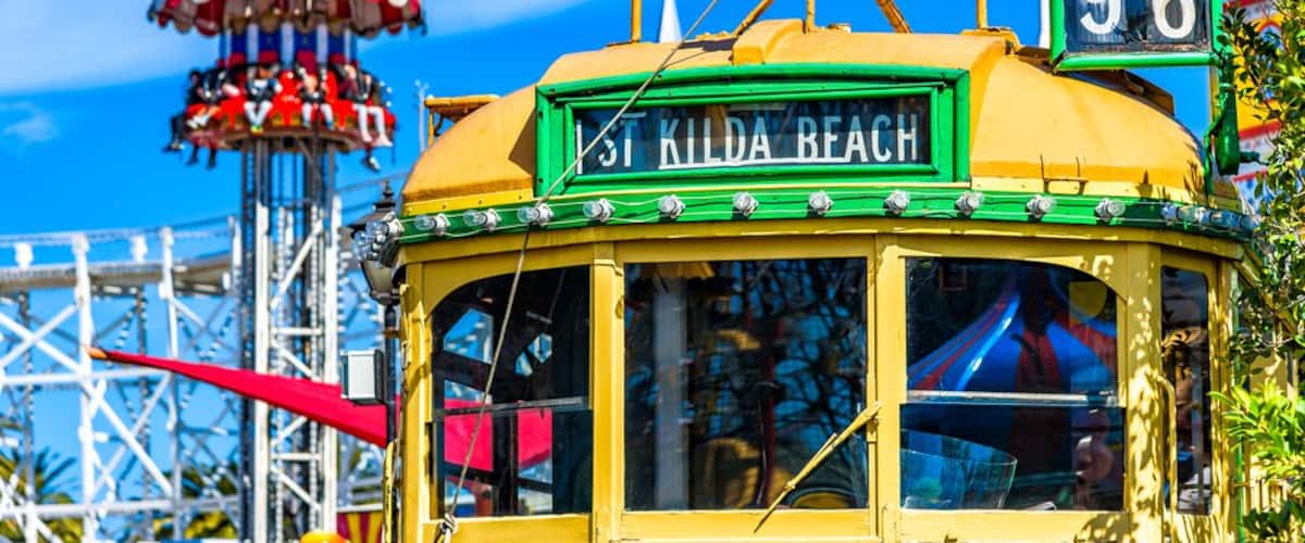 Vintage Melbourne W-Class Tram Images in St Kilda with fun fair rides in the background; Shutterstock ID 723153298; PO: Hcom Destination Content neighborhoods; Client: Hotels.com; Other: Hcom brand bu