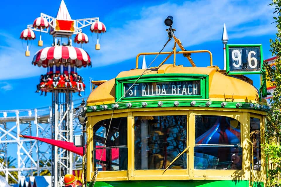 Un tram colorit amb la inscripció 'Kilda Beach', una noria i un cartell amb el número '96'.