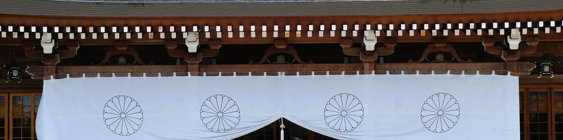 A traditional Japanese building with a large white banner featuring circular designs.