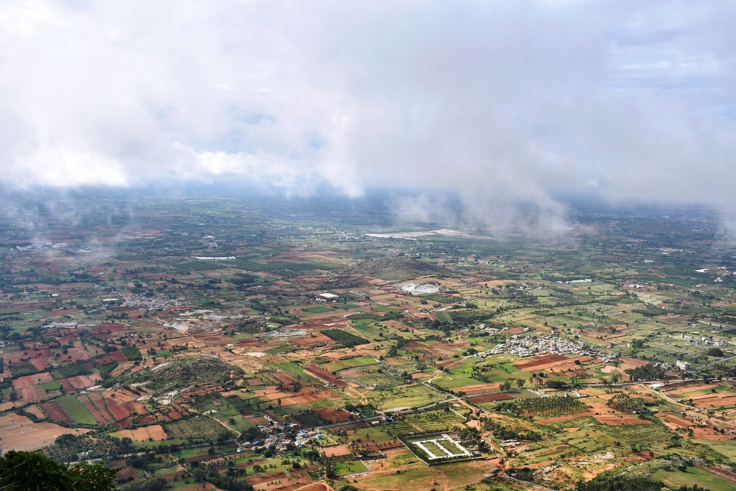 This is the beautiful view from atop Nandi Hill just when the sun clears up the clouds for a second. The clouds, greenery and the red fields make a colorful picture. #nandihills #sunriseviewpoint 
