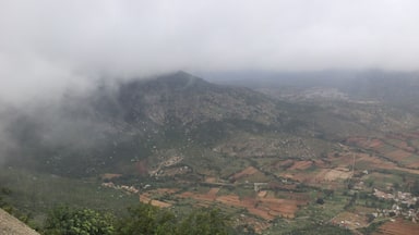 Paisagem montanhosa com campos e uma aldeia.
