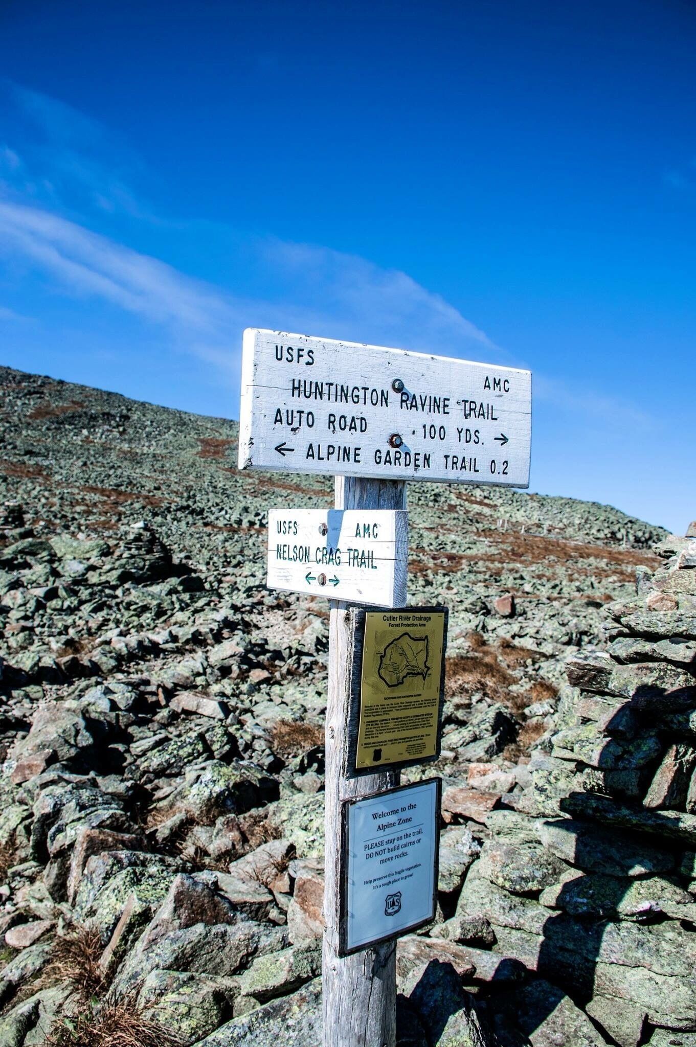 A trail sign with directions to Huntington Ravine Trail, Alpine Garden Trail, and Nelson Crag Trail.