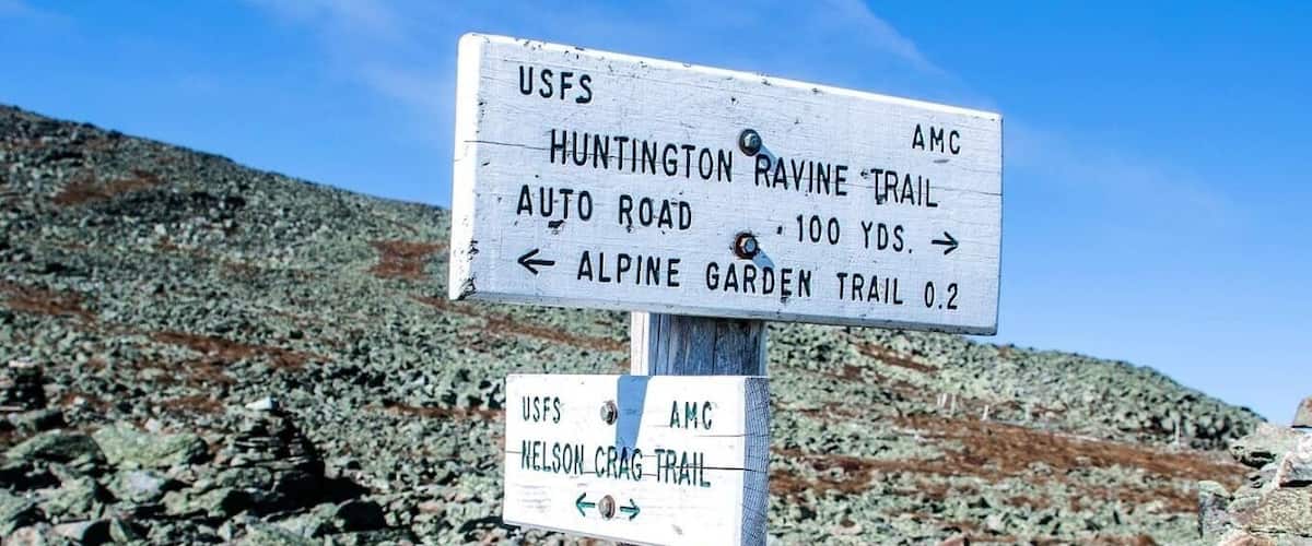 A trail sign with directions to Huntington Ravine Trail, Alpine Garden Trail, and Nelson Crag Trail.