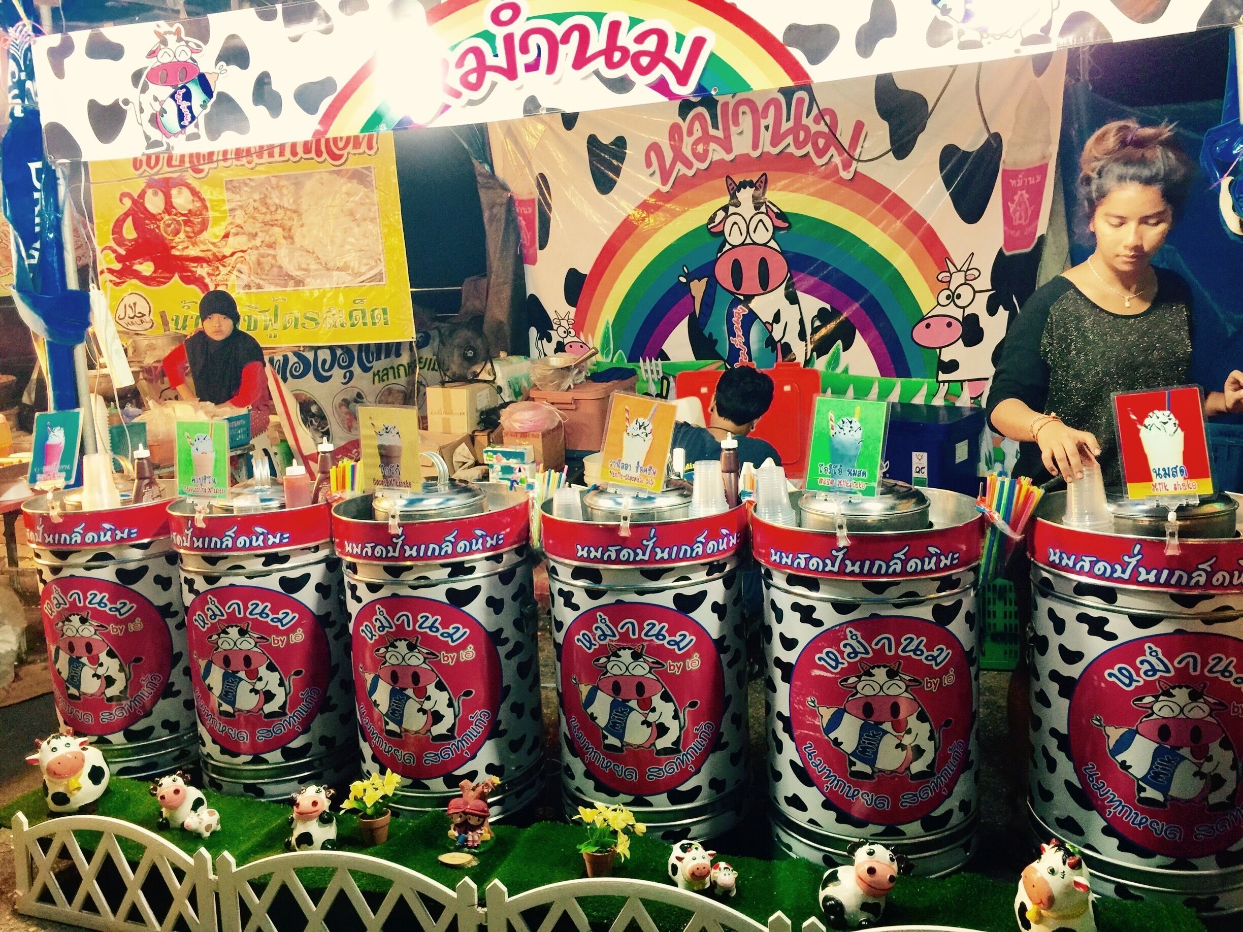 Um quiosque colorido com dispensadores de milkshake e decoração com tema de vaca.