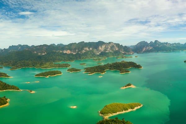 Eine Küstenlandschaft mit zahlreichen kleinen Inseln, umgeben von türkisblauem Wasser und dichten, grünen Wäldern.