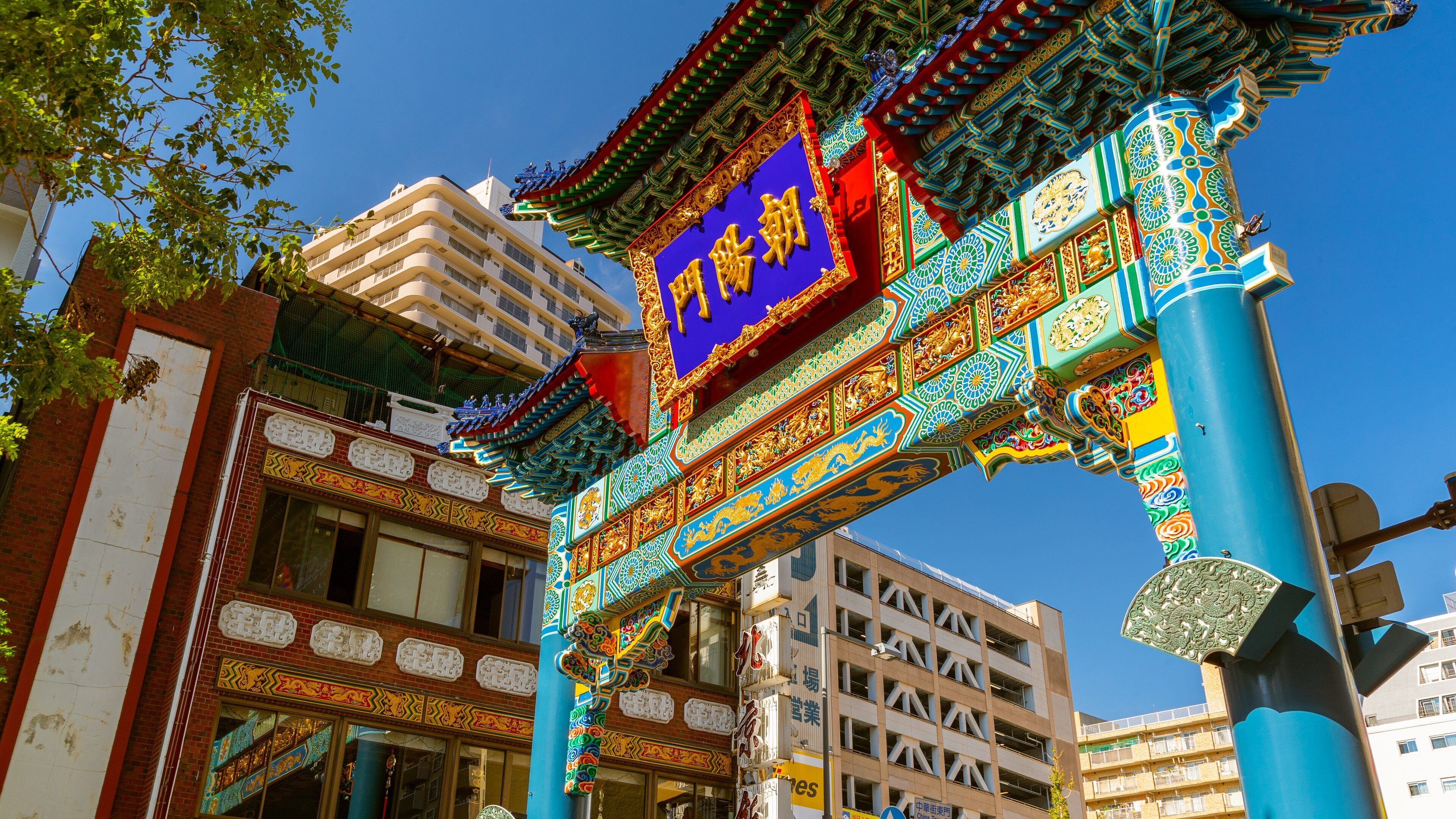A traditional Chinese gate with intricate designs and a blue sign with gold characters.