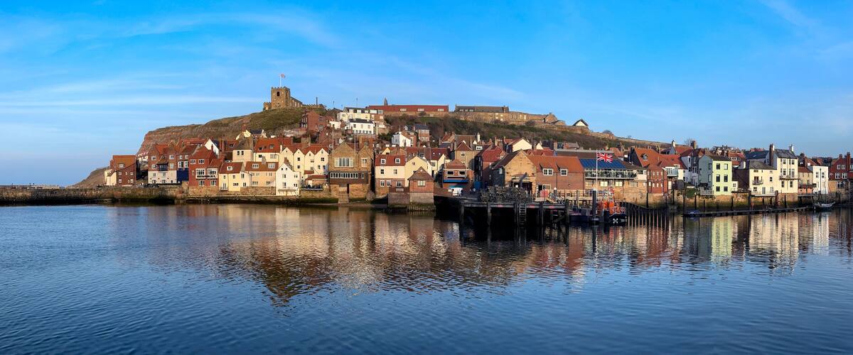 A coastal town with historic buildings and a prominent castle on a hill.